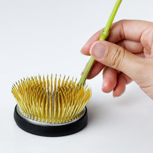 Load image into Gallery viewer, Hand holding a flower stemp platedn on the radial kenzan
