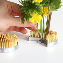 Load image into Gallery viewer, Hand arranging small yellow flowers on kenzan