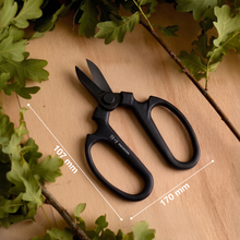 Load image into Gallery viewer, Black pruning shears on a wooden surface with green leaves
