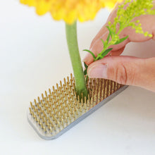 Load image into Gallery viewer, hand planting a flower stem on the long rectangular kenzan
